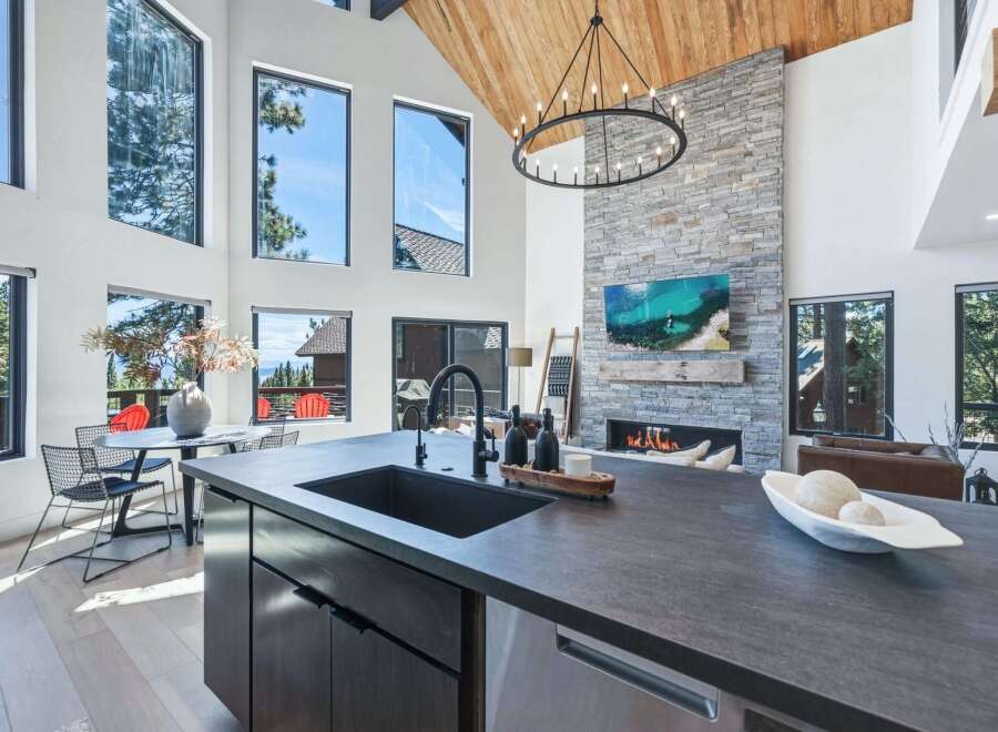 Experience luxury living in this stunning modern home featuring a grand living area with a soaring vaulted ceiling and a magnificent stone fireplace.