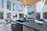 Experience luxury living in this stunning modern home featuring a grand living area with a soaring vaulted ceiling and a magnificent stone fireplace.