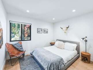 Experience rustic charm in this inviting bedroom, featuring a comfortable bed adorned with plush linens and a cozy grey throw.