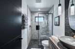 Experience modern luxury in this stunning bathroom featuring a sleek glass-enclosed shower with marble tile and a pebble-stone floor.