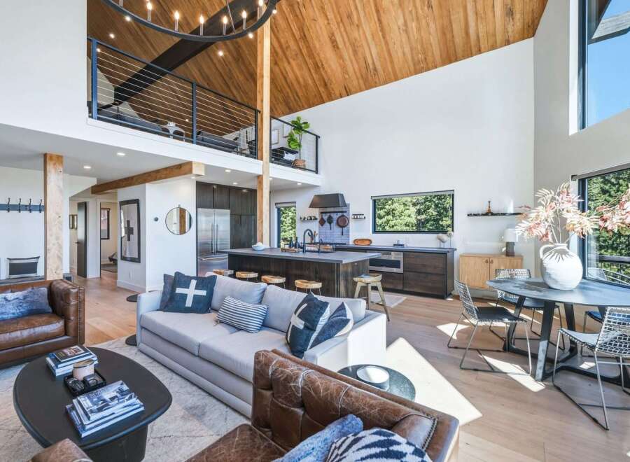Experience modern living in this stunning open-concept home, featuring a soaring vaulted wood-beamed ceiling and a chic loft overlooking the main living area.