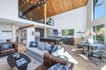 Experience modern living in this stunning open-concept home, featuring a soaring vaulted wood-beamed ceiling and a chic loft overlooking the main living area.