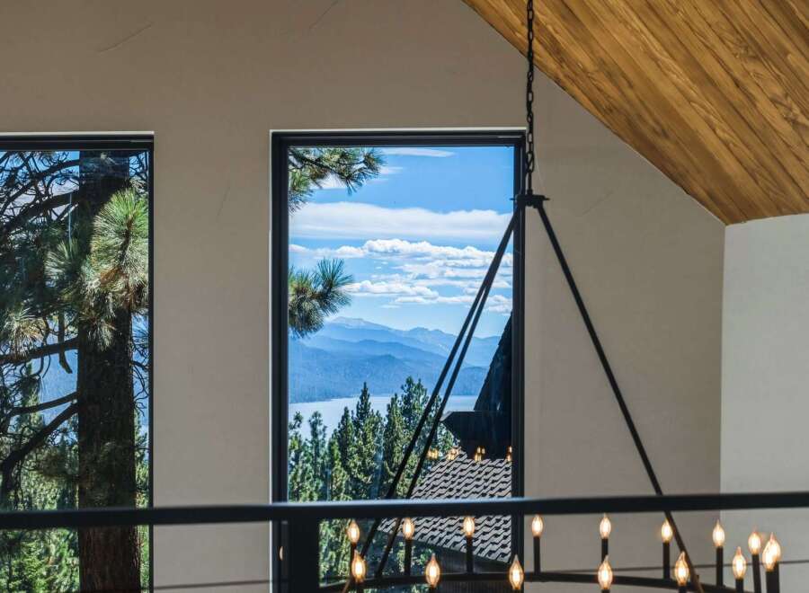 Experience breathtaking panoramic views of a serene lake and majestic mountains from this stunning property.