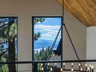 Experience breathtaking panoramic views of a serene lake and majestic mountains from this stunning property.