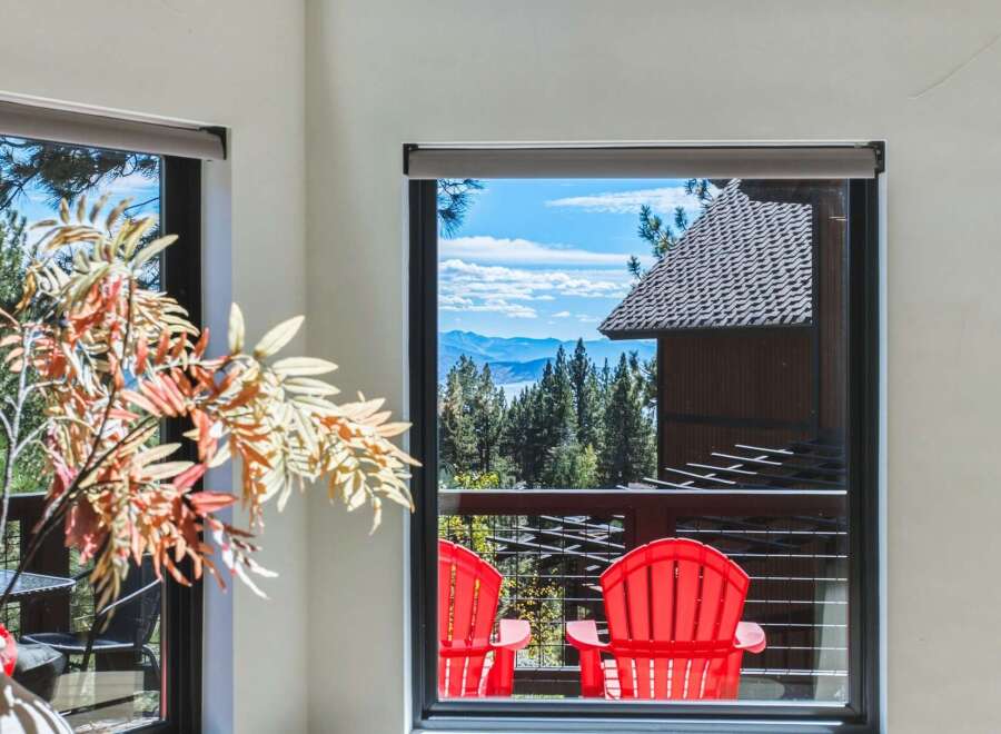 Enjoy breathtaking mountain and lake views from this stunning property, framed by a large window.