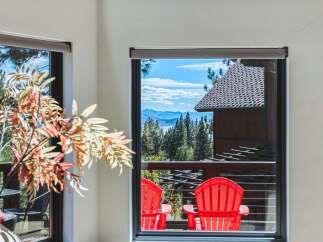 Enjoy breathtaking mountain and lake views from this stunning property, framed by a large window.
