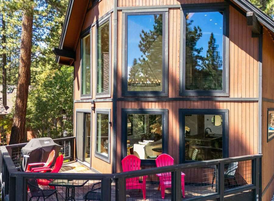Experience mountain living in this charming cabin featuring a spacious deck with a grill and seating, perfect for outdoor entertaining.