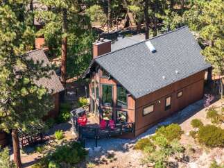 Nestled amidst tall pine trees, this charming brown cabin offers a serene mountain retreat.