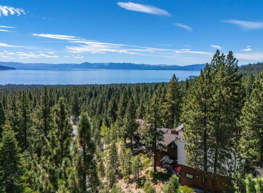 Experience breathtaking panoramic views of Lake Tahoe from this stunning property nestled amidst a dense pine forest.