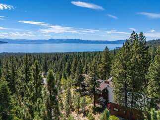 Experience breathtaking panoramic views of Lake Tahoe from this stunning property nestled amidst a dense pine forest.