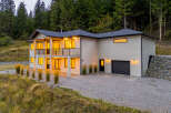Discover this stunning modern home nestled against a backdrop of lush evergreen trees.