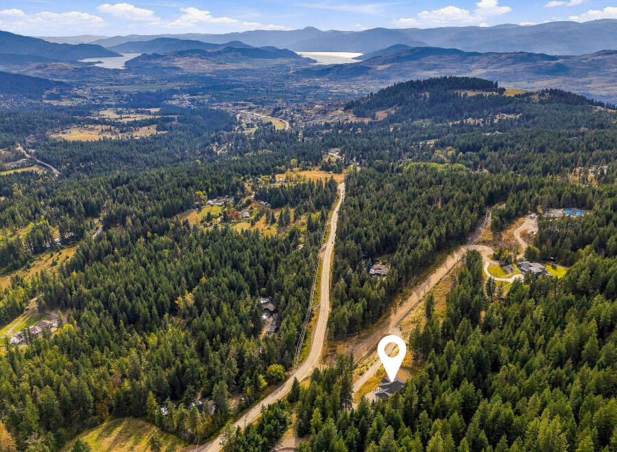 Experience luxury living nestled within a private, wooded estate offering breathtaking panoramic views of the valley and distant mountains.
