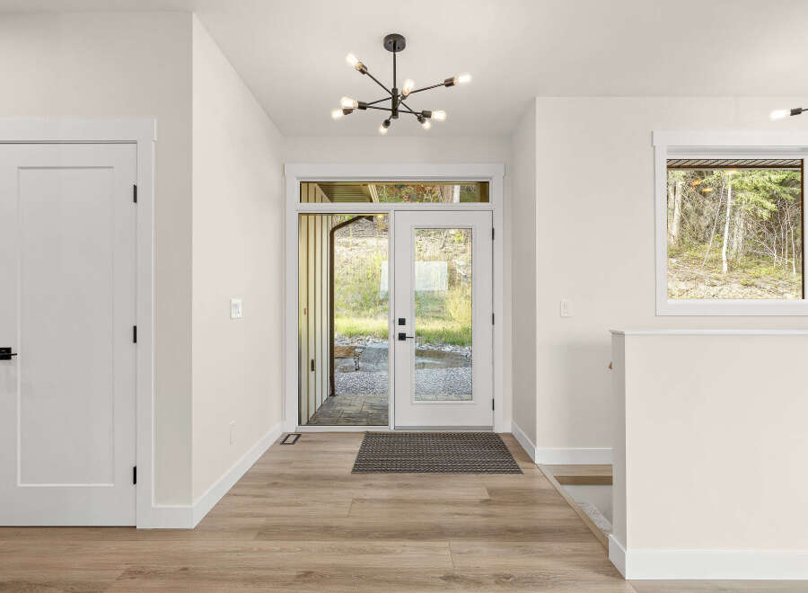 Step into this inviting entryway featuring a modern sputnik chandelier and a sleek double door leading to the outdoors.