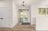 Step into this inviting entryway featuring a modern sputnik chandelier and a sleek double door leading to the outdoors.