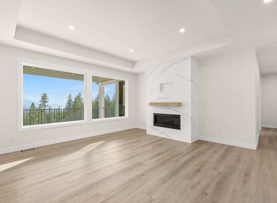 Experience breathtaking views from this spacious living area, featuring a modern fireplace with marble accents and a large picture window.