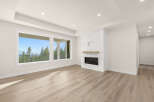 Experience breathtaking views from this spacious living area, featuring a modern fireplace with marble accents and a large picture window.
