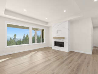 Experience breathtaking views from this spacious living area, featuring a modern fireplace with marble accents and a large picture window.