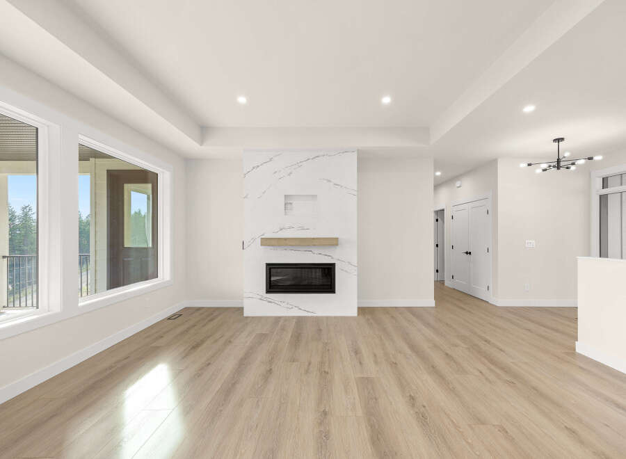 Experience modern living in this spacious open-concept living area, featuring a stunning marble fireplace as the focal point.