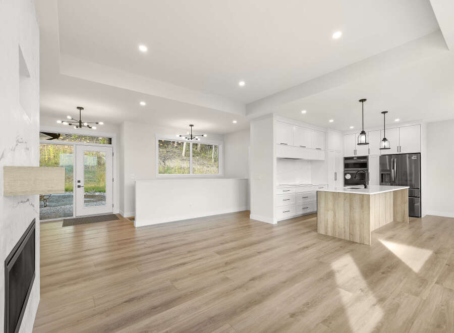 Experience modern living in this stunning open-concept home, featuring a sleek kitchen with a large island and ample cabinet space.