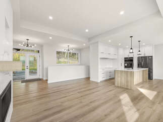 Experience modern living in this stunning open-concept home, featuring a sleek kitchen with a large island and ample cabinet space.