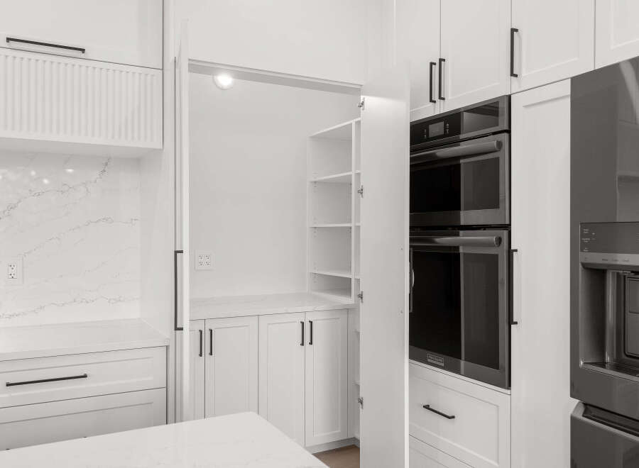 Experience modern kitchen luxury with sleek white cabinetry and a stunning marble backsplash.