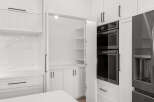 Experience modern kitchen luxury with sleek white cabinetry and a stunning marble backsplash.