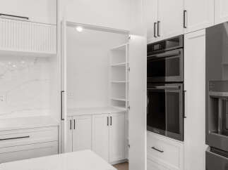 Experience modern kitchen luxury with sleek white cabinetry and a stunning marble backsplash.