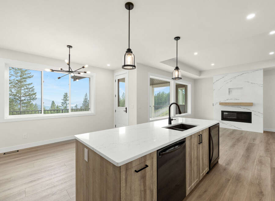 Experience modern living in this stunning open-concept kitchen and living area, featuring a sleek island with a double sink and a beautiful quartz countertop.