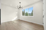 Experience breathtaking views from this spacious room, featuring a large picture window that frames a stunning landscape of rolling hills and lush trees.