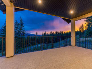 Experience breathtaking sunset views from this expansive covered balcony, perfect for enjoying the serene mountain landscape.
