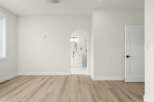 Step into this beautifully renovated space featuring a modern open-concept layout with sleek, light-wood flooring.