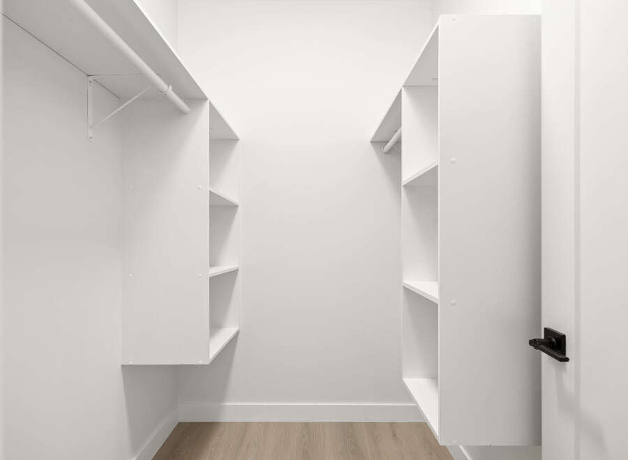 Step into this spacious walk-in closet, featuring ample shelving and hanging space to organize your wardrobe.
