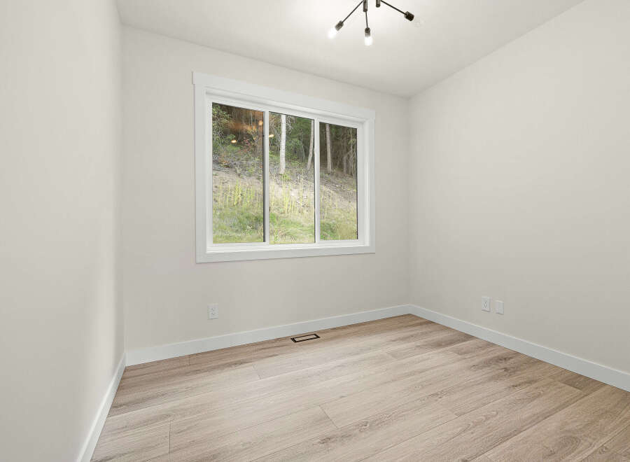 This bright and airy room features a large window offering scenic views of the surrounding greenery.