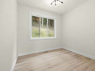 This bright and airy room features a large window offering scenic views of the surrounding greenery.