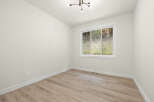 This empty room features a large sliding window offering a view of the natural landscape.