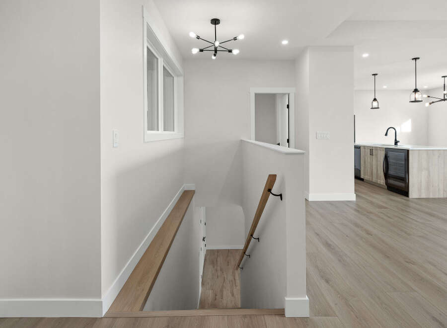 Step into a modern and bright open-concept living space, featuring a sleek kitchen island with a wine fridge and contemporary pendant lighting.