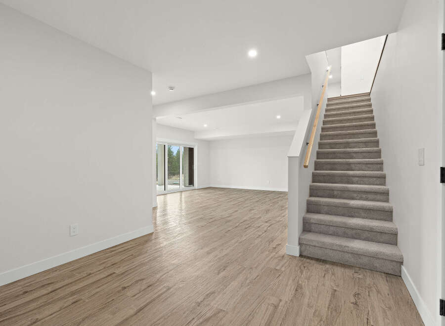 Discover this spacious and bright basement with a modern aesthetic, featuring elegant wood-look flooring and a neutral color palette.
