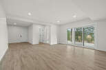 Step into this bright and airy finished basement, featuring a spacious open-concept living area with elegant wood-look flooring.