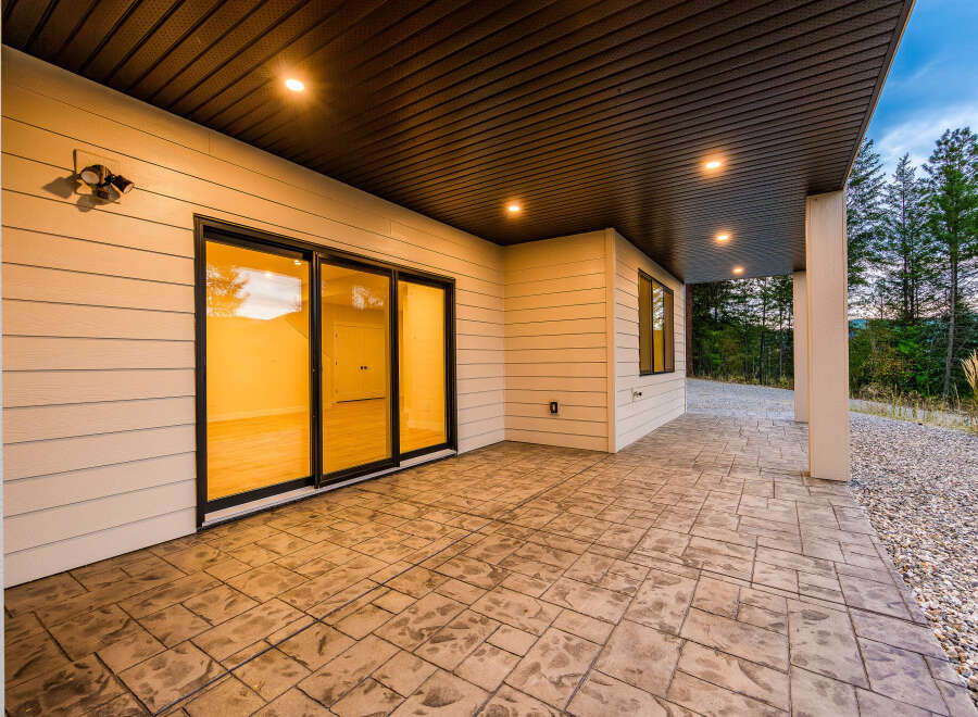 Experience seamless indoor-outdoor living with this stunning covered patio, featuring elegant stamped concrete flooring and recessed lighting for evening ambiance.