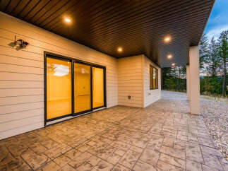 Experience seamless indoor-outdoor living with this stunning covered patio, featuring elegant stamped concrete flooring and recessed lighting for evening ambiance.