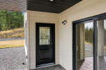 This property features a modern exterior with a black-trimmed glass door and a sliding glass door leading to an outdoor space.