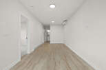 Step into this bright and airy hallway, featuring modern light wood laminate flooring and crisp white walls.