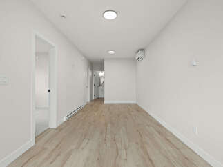 Step into this bright and airy hallway, featuring modern light wood laminate flooring and crisp white walls.