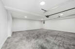 This spacious garage offers a clean and modern aesthetic with its polished concrete floors and bright white walls.