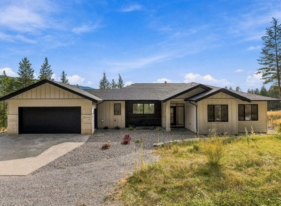 Discover modern living in this stunning single-story home, featuring a sleek design with a mix of siding and brick accents.
