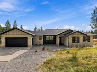Discover modern living in this stunning single-story home, featuring a sleek design with a mix of siding and brick accents.