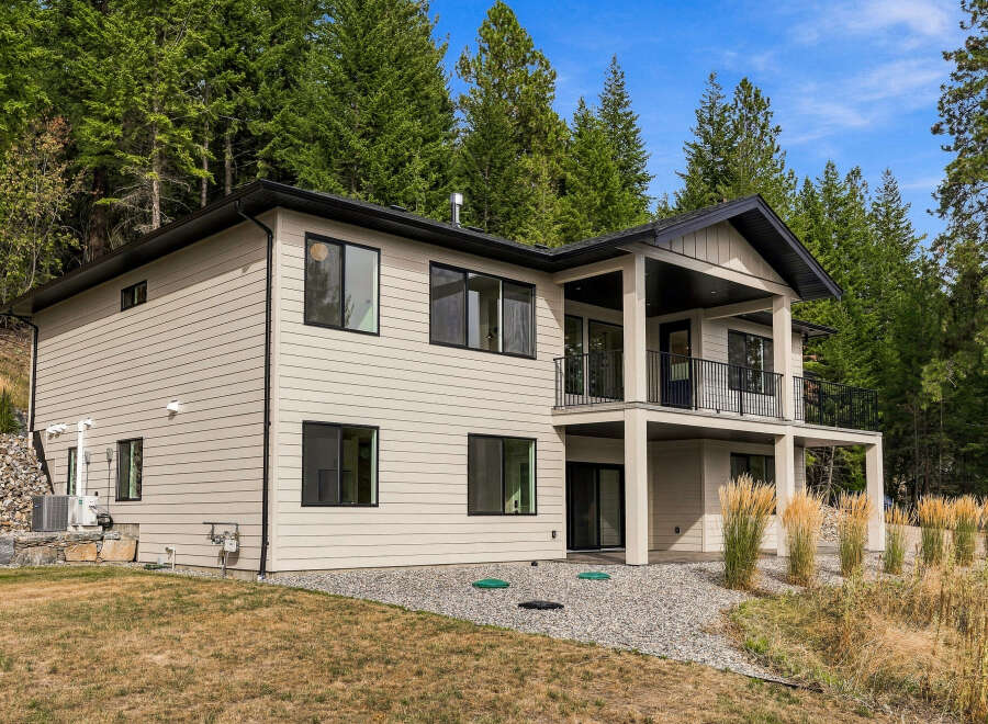 Discover modern living in this stunning two-story home nestled amongst lush evergreen trees.
