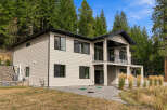 Discover modern living in this stunning two-story home nestled amongst lush evergreen trees.