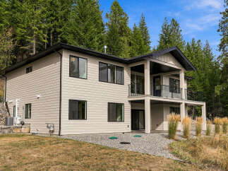Discover modern living in this stunning two-story home nestled amongst lush evergreen trees.
