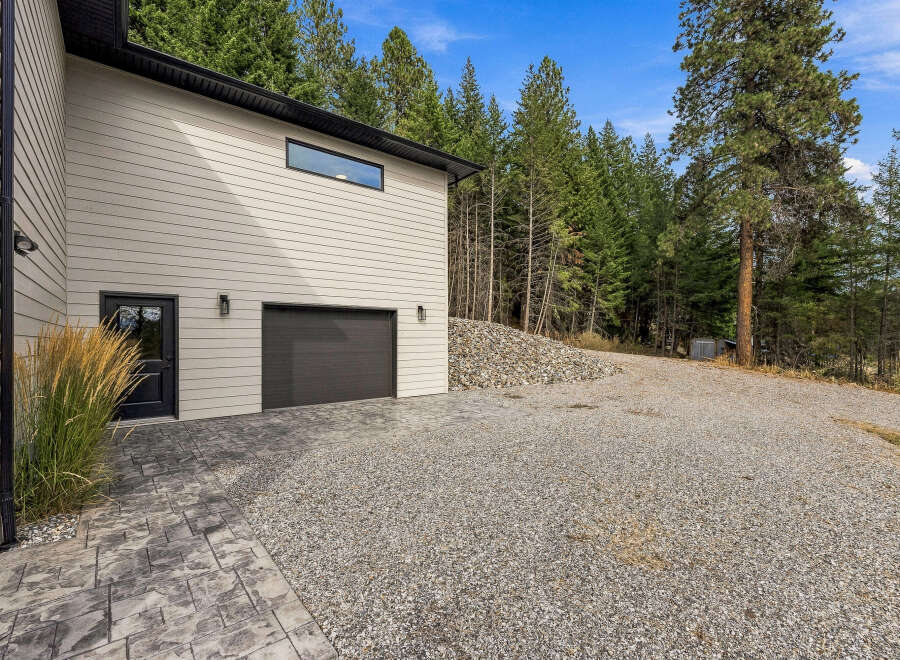 Discover this stunning property featuring a modern garage with a sleek dark door and a stylish horizontal window.